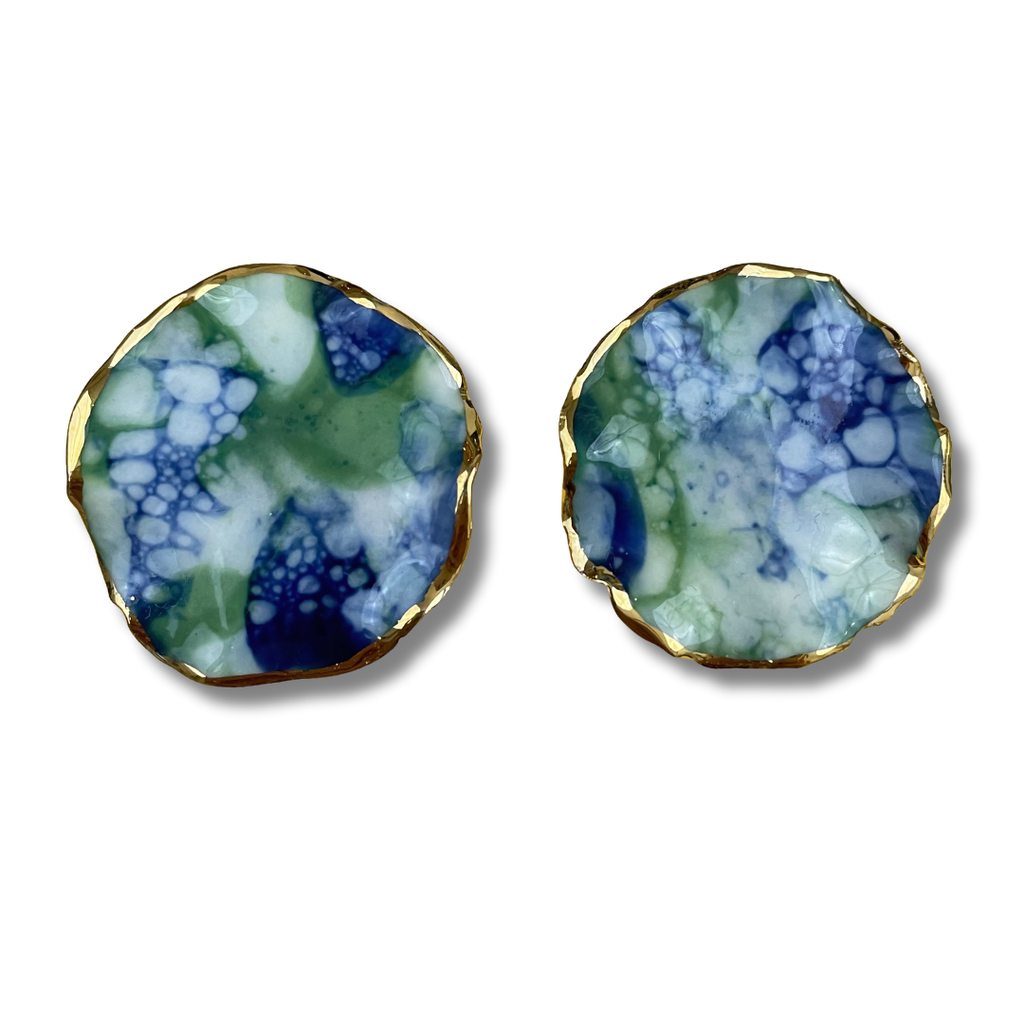 Pair of earrings with a blue and green marbled design and a gold border on a white background.
