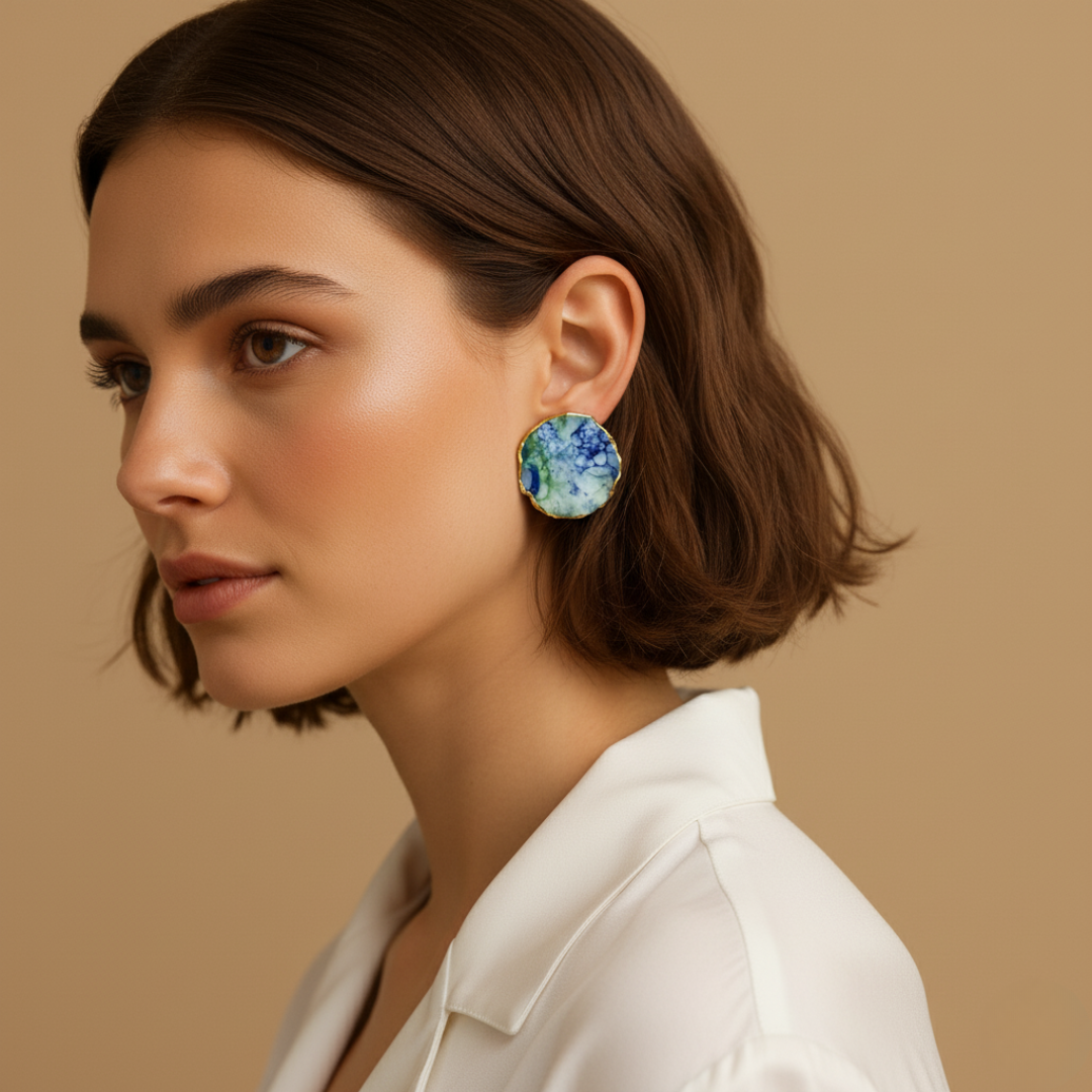 Woman wearing colorful earrings against a beige background.