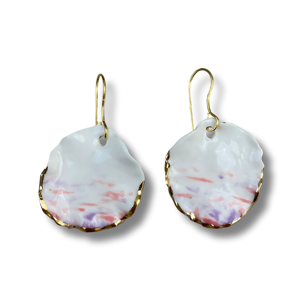 Pair of white, pink, and purple earrings with gold accents on a white background