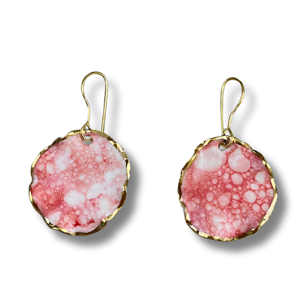 Pink marbled earrings with gold rims on a white background