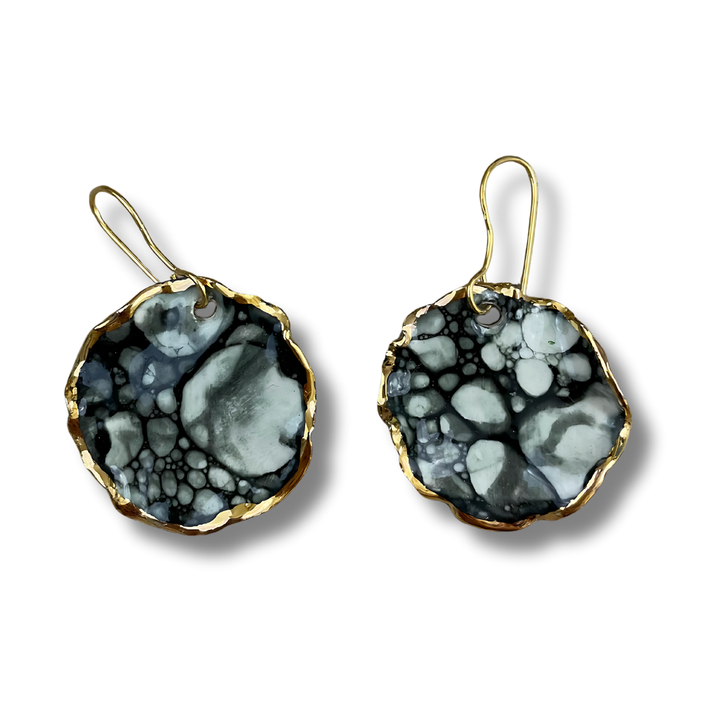 Black and white earrings with gold accents on a white background