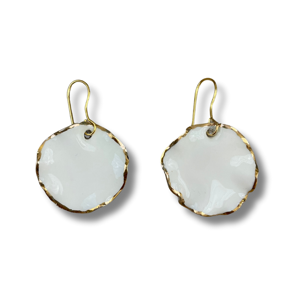 Pair of white earrings with gold rims on a white background