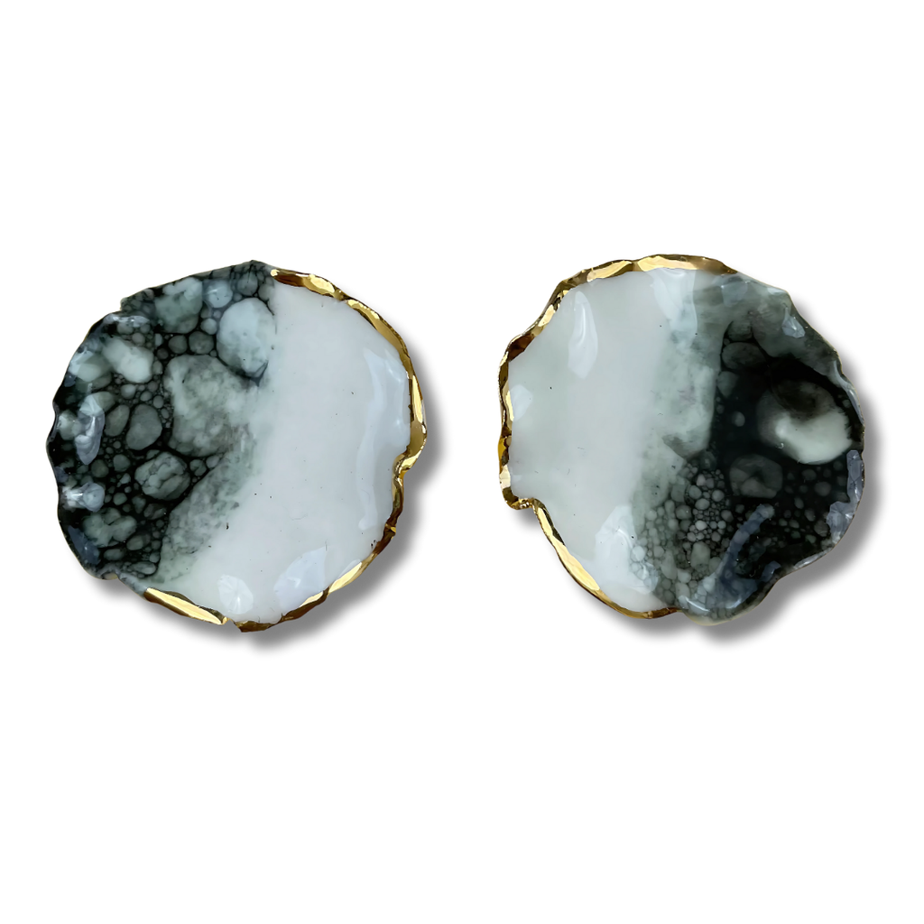 Pair of earrings with a black, white, and gold design on a white background