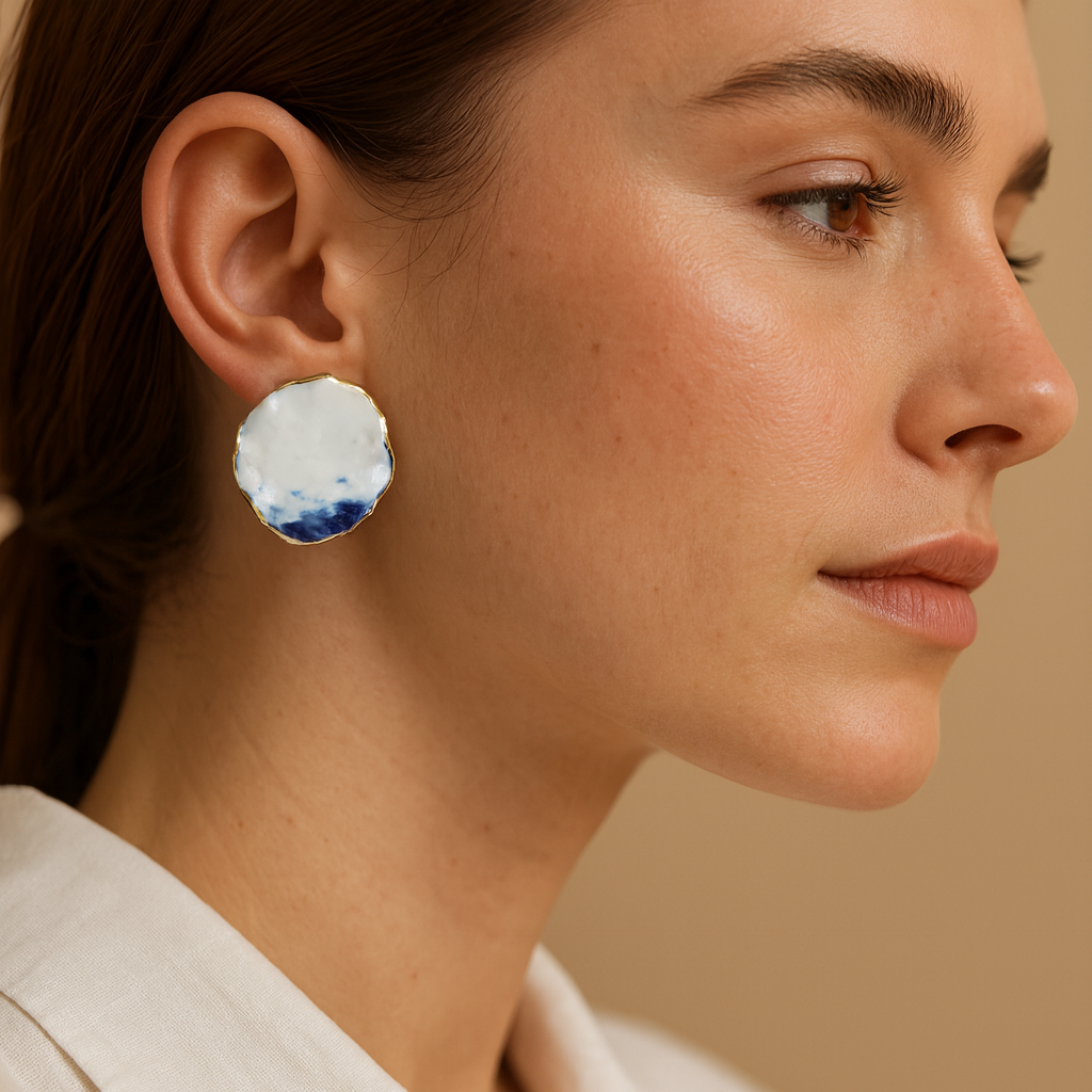 Close-up of a woman wearing a pair of earrings with a blue and white design.