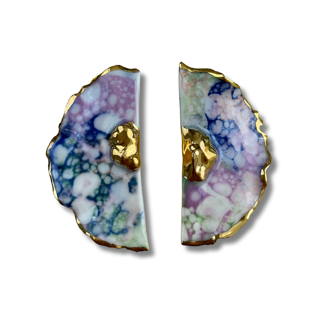 Pair of multicolored earrings and gold accents on a white background