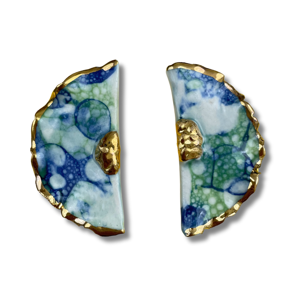 Pair of blue and green earrings with gold accents on a white background.