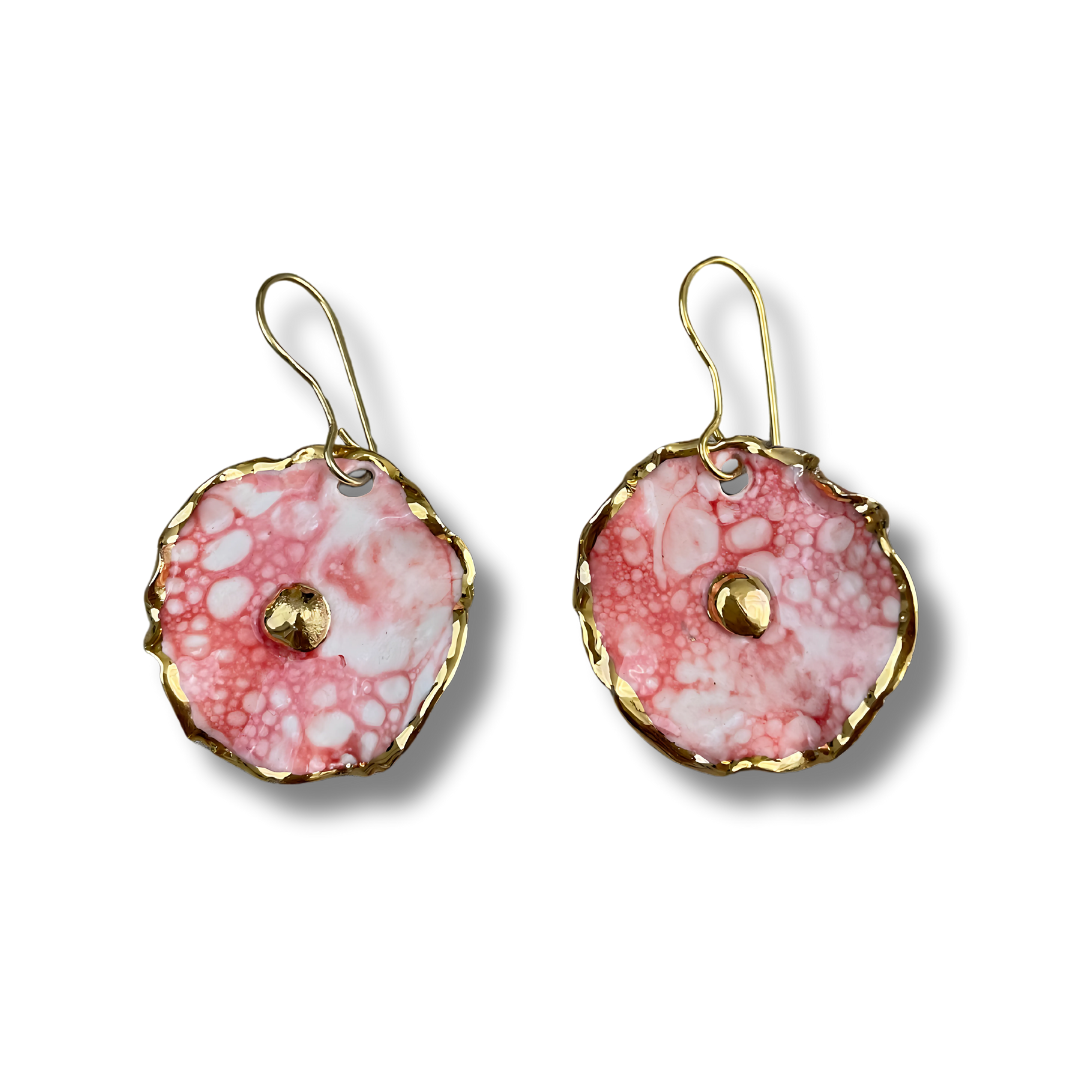 Pair of earrings with a pink and white design and gold accents on a white background