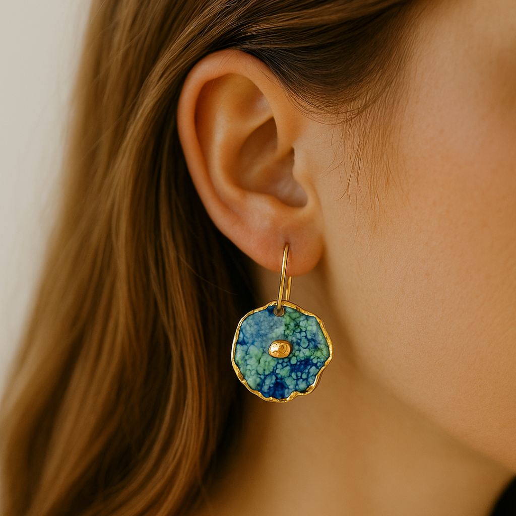 Close-up of an ear wearing a blue, green, and gold earring.