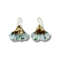Pair of earrings with a gold and green ginkgo design and gold details on a white background
