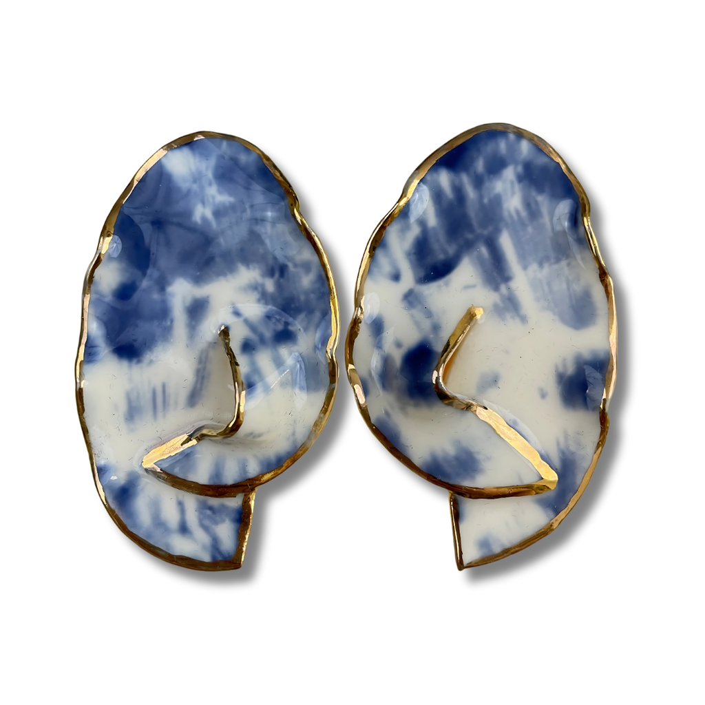 Pair of earrings with a blue and white abstract design on a white background