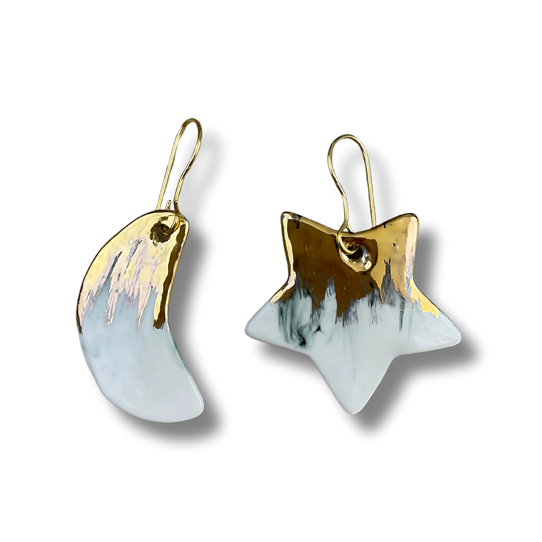 Pair of earrings with gold and white design on a white background