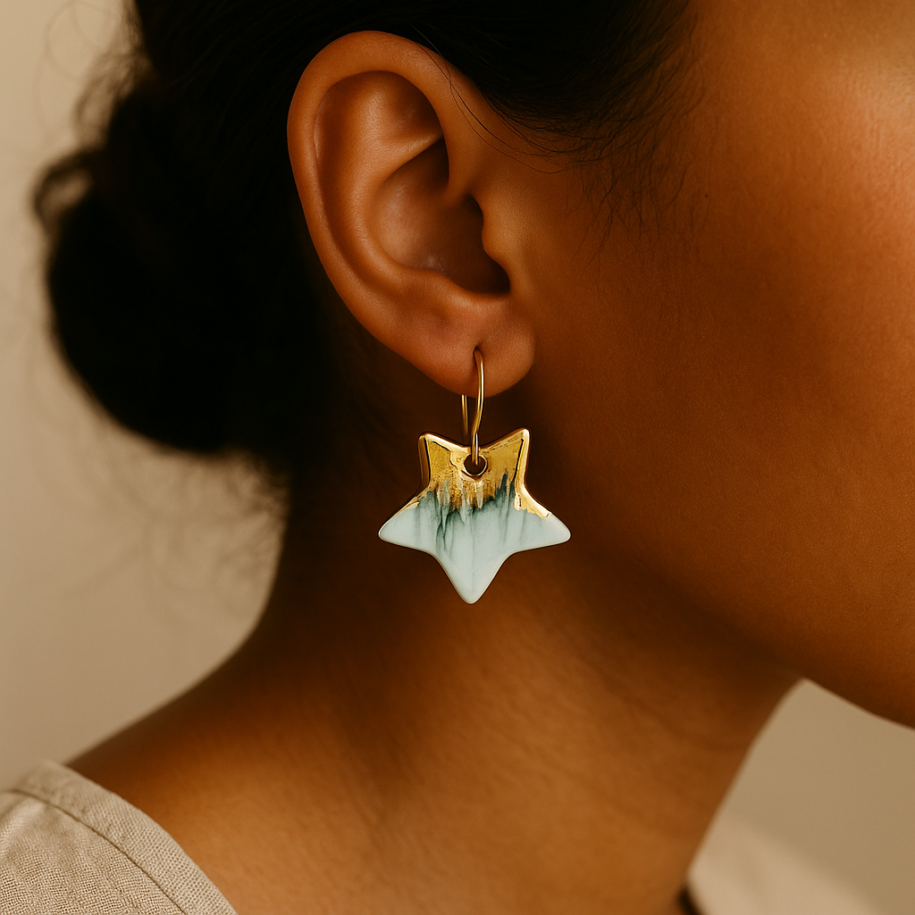 Close-up of a person wearing a white and gold star-shaped earring.