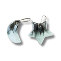 Pair of white and platinum earrings, star and moon shaped, on a white background