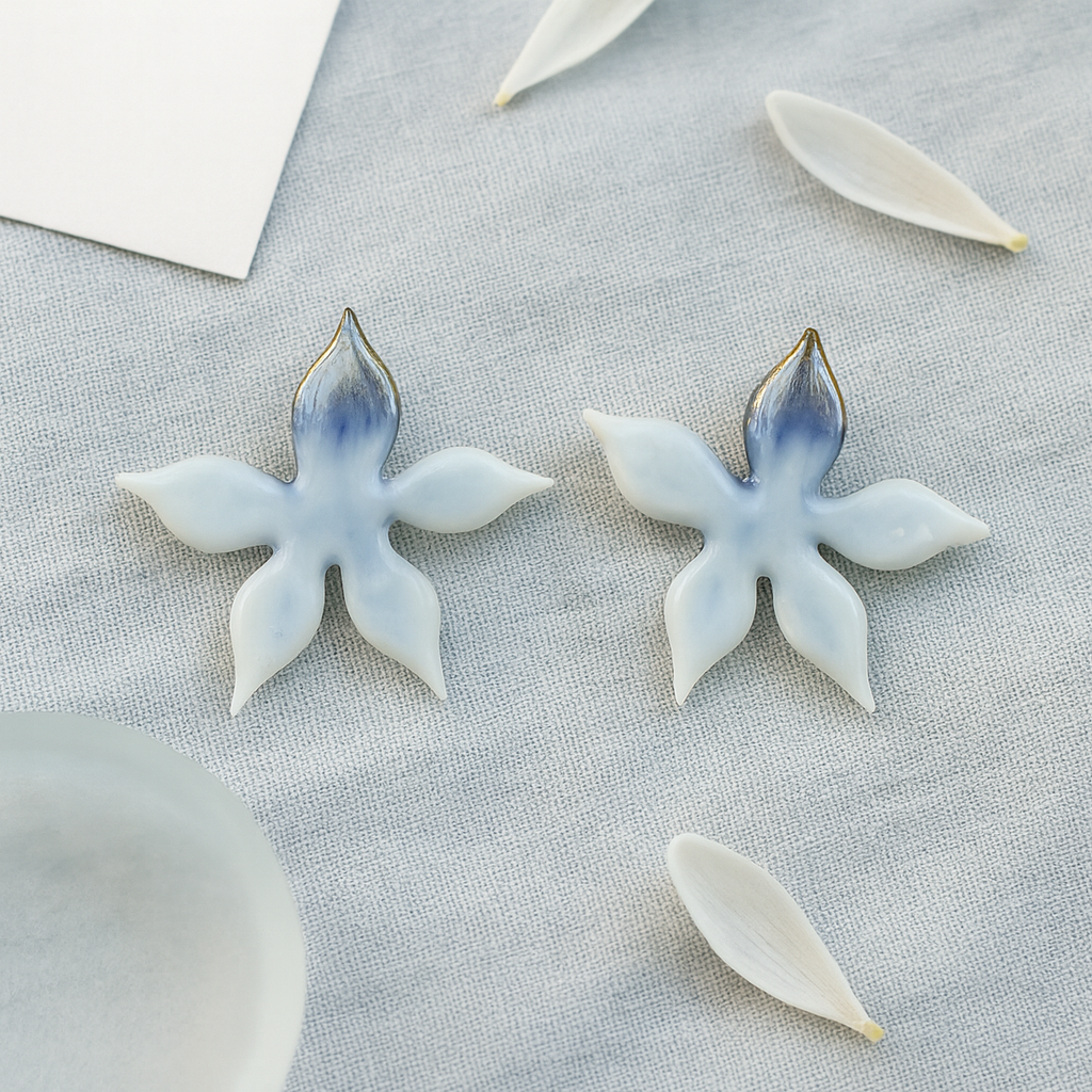Pair of porcelain star-shaped earrings on a textured surface