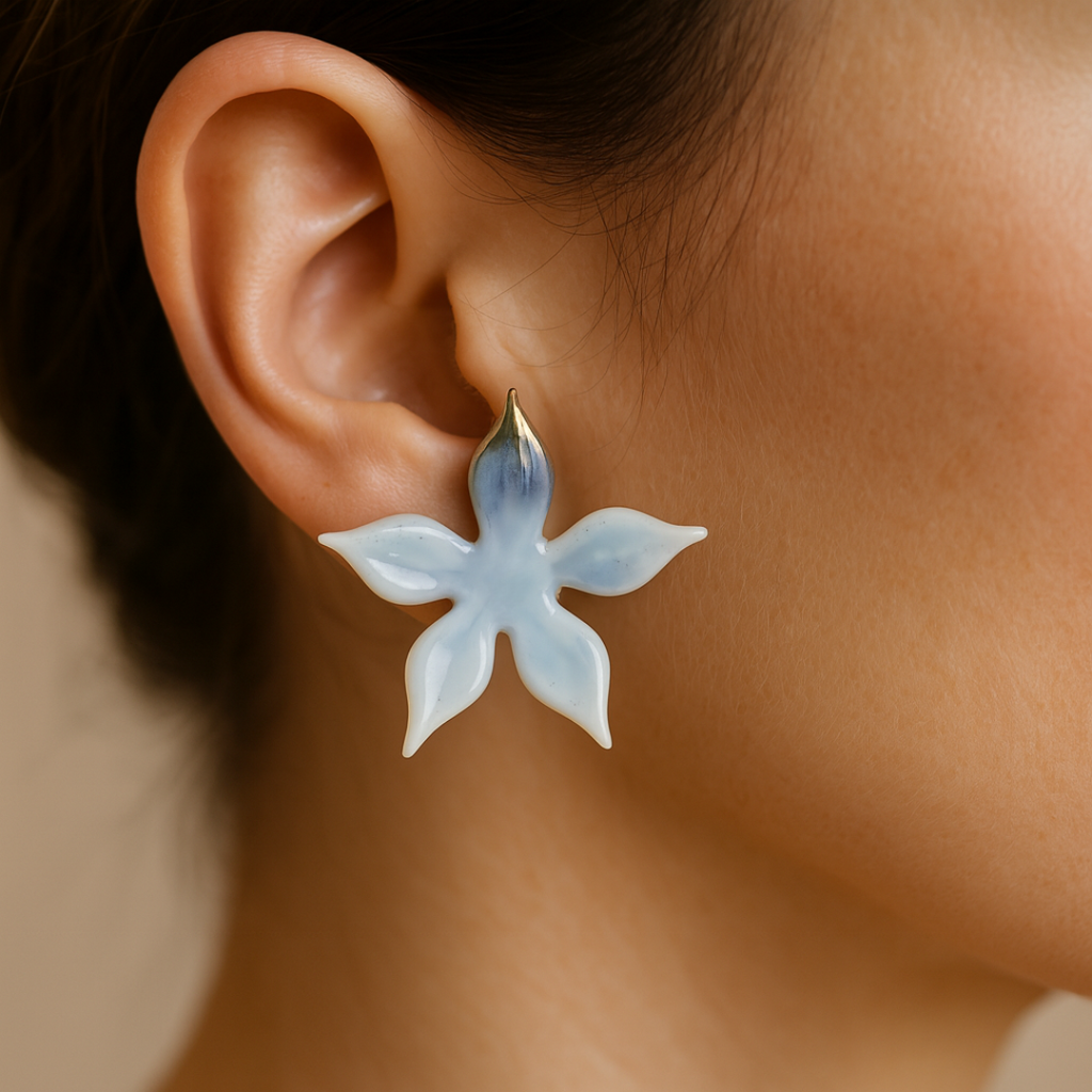 A star earring worn by a person with a neutral background